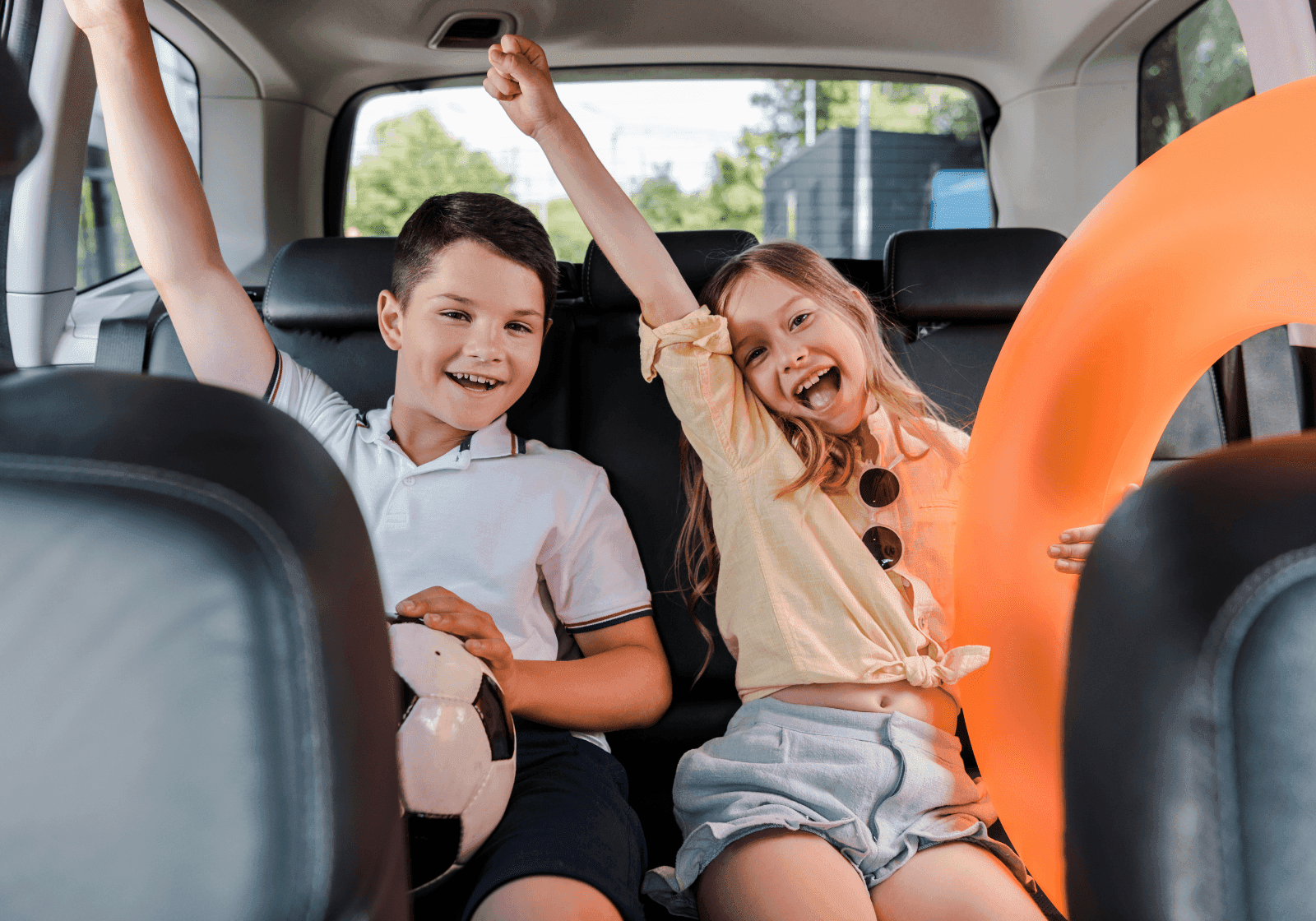 To børn på bagsædet i en bil med legetøj