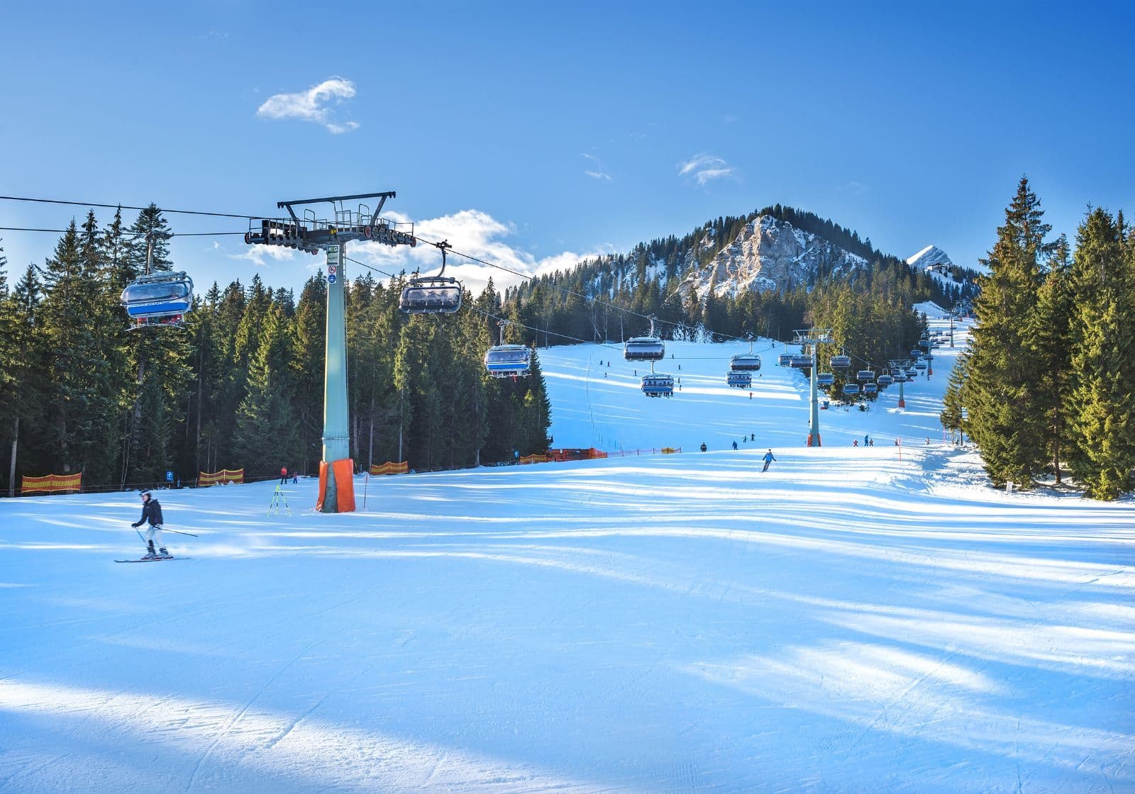 Skiløjpe med bjerge i baggrunden og skilift henover