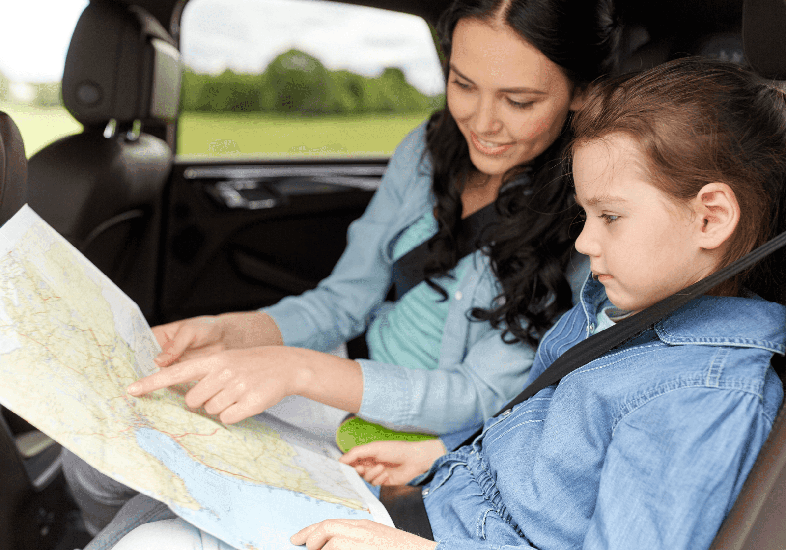 Mor og datter sidder i bil og kigger på et kort